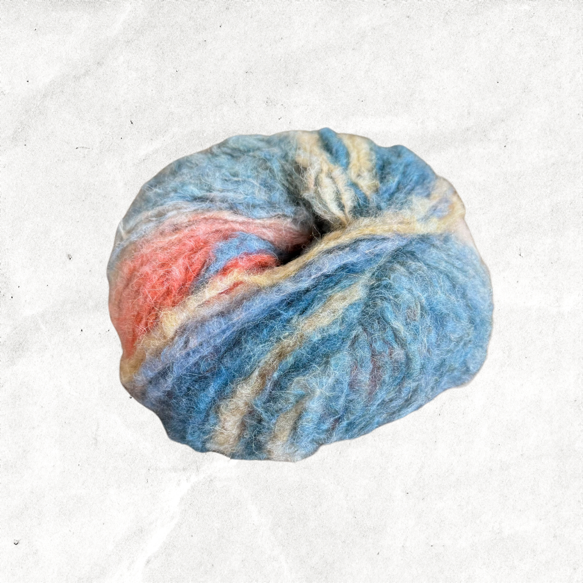 A fluffy ball of yarn with blue, grey, orange, and yellow tones.