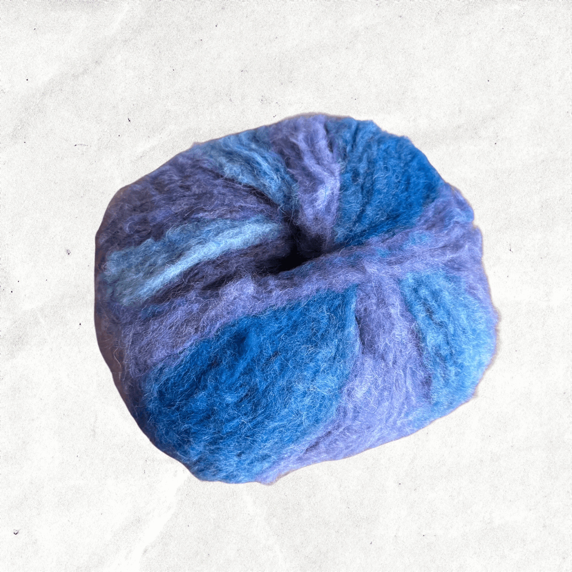 A fluffy ball of yarn with blue and purple tones.