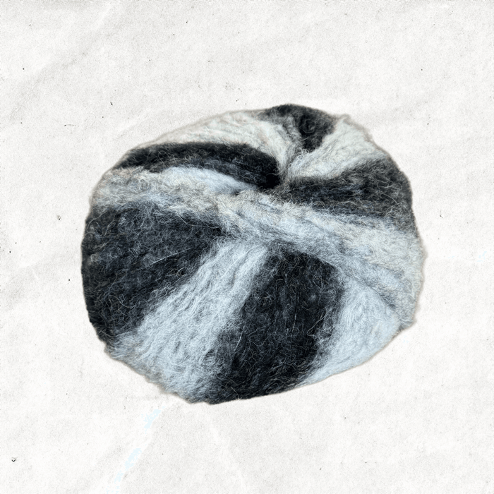 A fluffy ball of yarn with white and black tones.