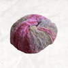 A fluffy ball of yarn with beige, grey, and pink tones.