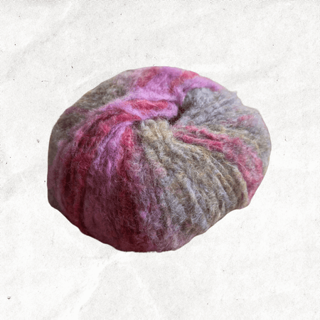A fluffy ball of yarn with beige, grey, and pink tones.