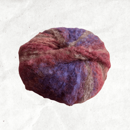 A fluffy ball of yarn with red, brown, and purple tones.