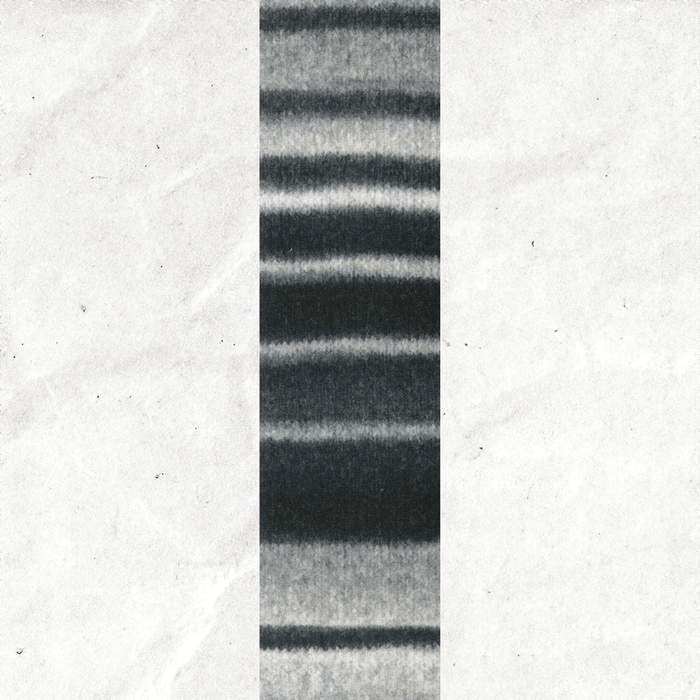 A yarn swatch showing the self striping pattern of the white and black tones.