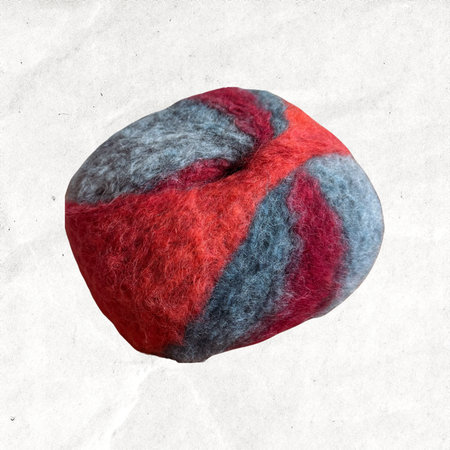 A fluffy ball of yarn with red, orange, and blue-grey tones.